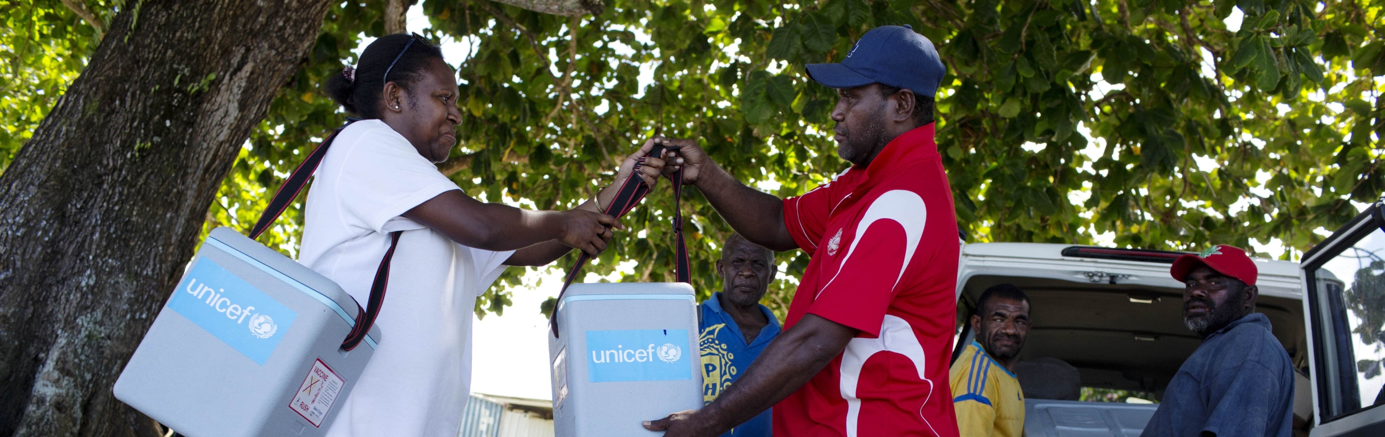 Image of PNG residents helping transport vaccines in coolers from UNICEF